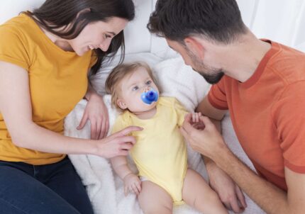 parents-holding-baby-bed
